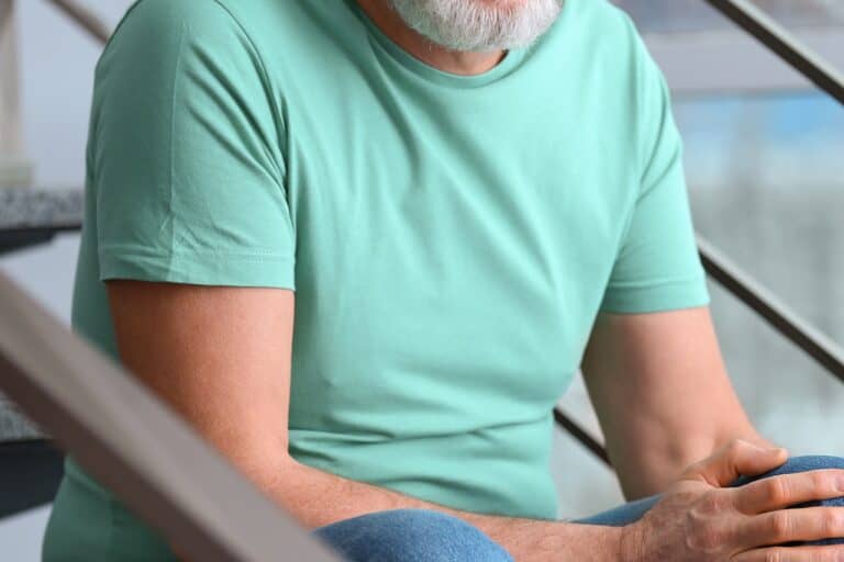 man in green shirt sitting on steps